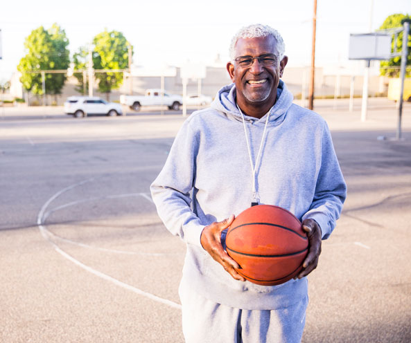 African american man holding basketball.