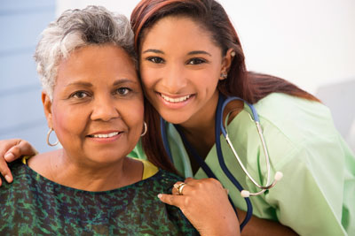 Caring, mixed-race nurse and senior adult patient in hospital.